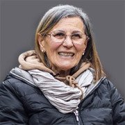 Older woman with glasses wearing coat and looking towards camera